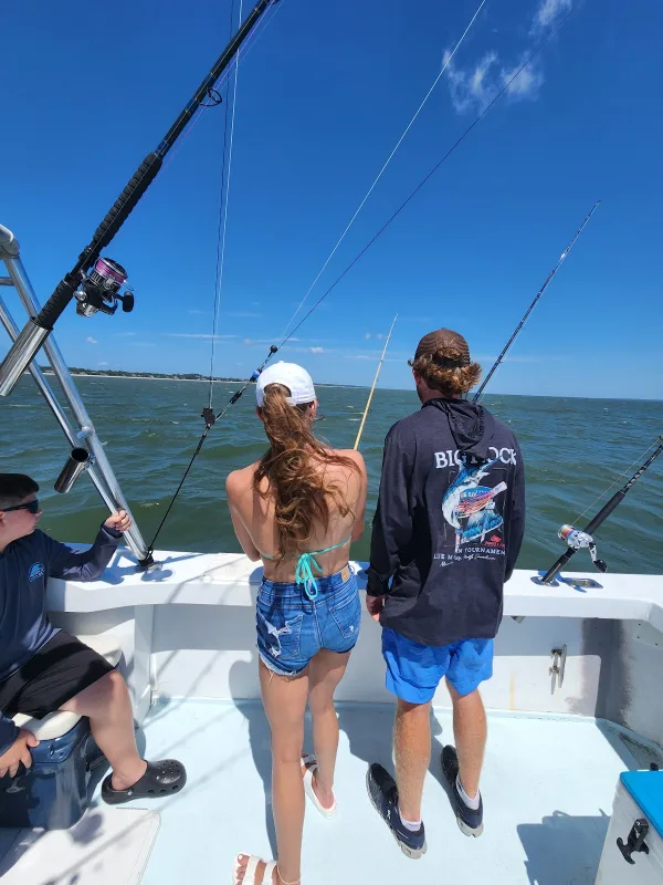 Two anglers fishing from the bow of a Black and Blue Charters boat