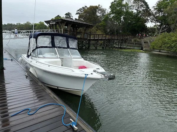A Captain Moto Adventures boat tied up at a wooden dock