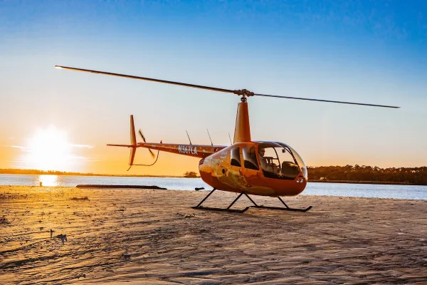 A Hilton Head Helicopter Tours helicopter on the beach at sunset