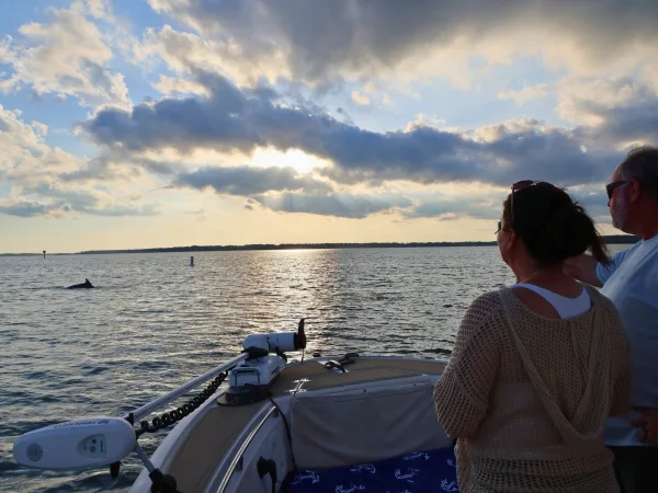 Guests watching the water at sunset on a Hilton Head Dolphin Tours boat