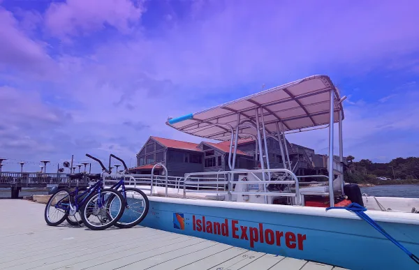 The Island Explorer tour boat and rental bikes at the dock for Island Life Rentals and Tours