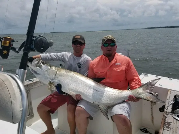 Two anglers holding a large fish aboard a Lowcountry Cowboy Fishing Charters boat