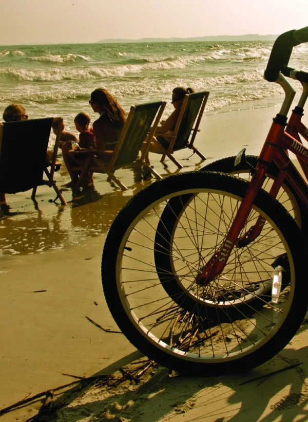 A LowSea rental bike on the beach with beach chairs behind it