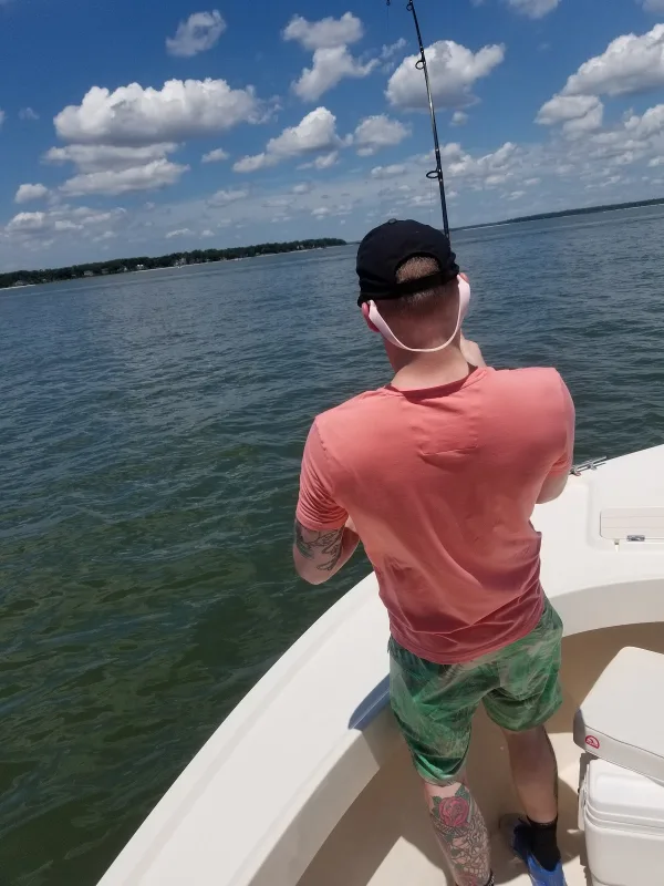 An angler reeling in from the bow of a Megabite Fishing Charters boat