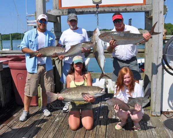 A family showing off their catch on the dock with North End Charter Fleet