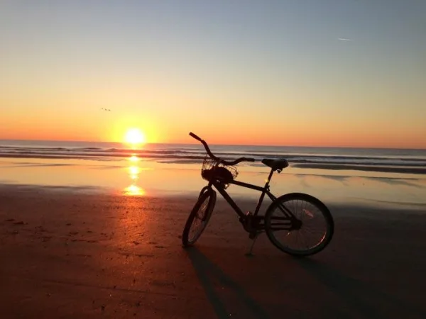A beach cruiser from Pedals Bicycles on the sand at sunrise