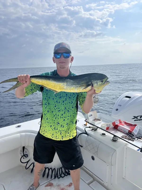 An angler holding a mahi-mahi on the Stray Cat Charters boat