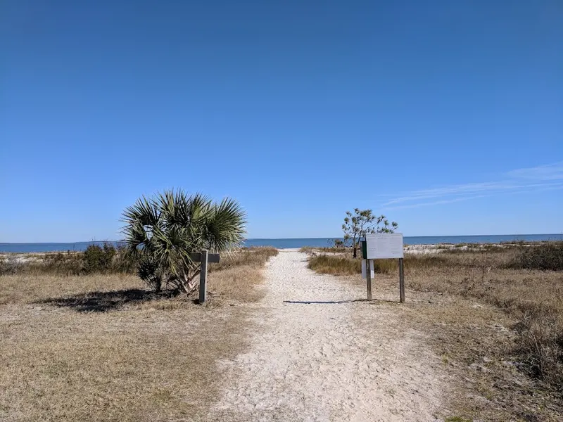 A sandy path through dune grass to the beach at Port Royal Plantation, with a marker beside it