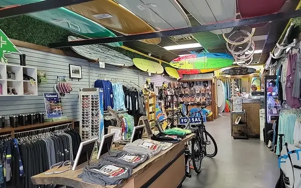 Inside the Forest Beach Surf & Cycle shop, surfboards hung from the ceiling over racks of clothes