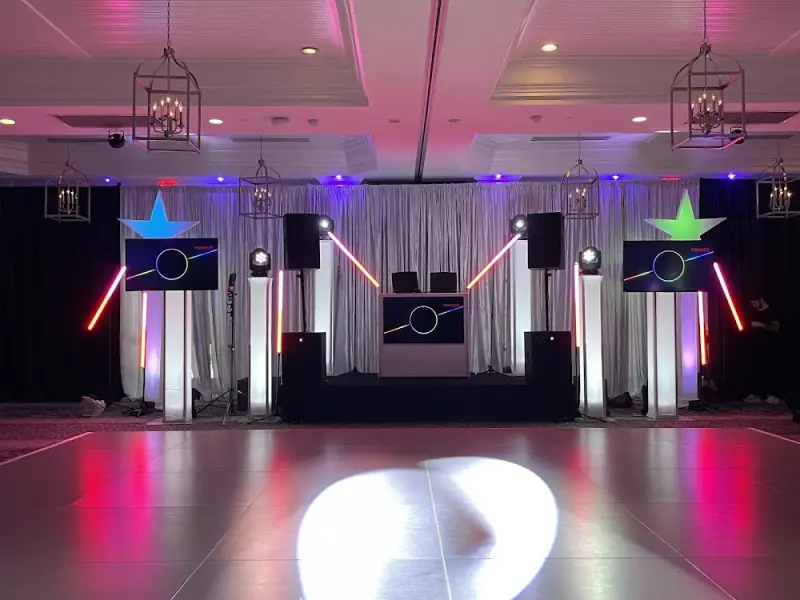 A JLK Events DJ booth with uplighting and a dance floor in a reception room